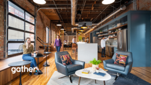 An open coworking area at Gather Downtown Richmond showing professionals working, talking, and using the community kitchen